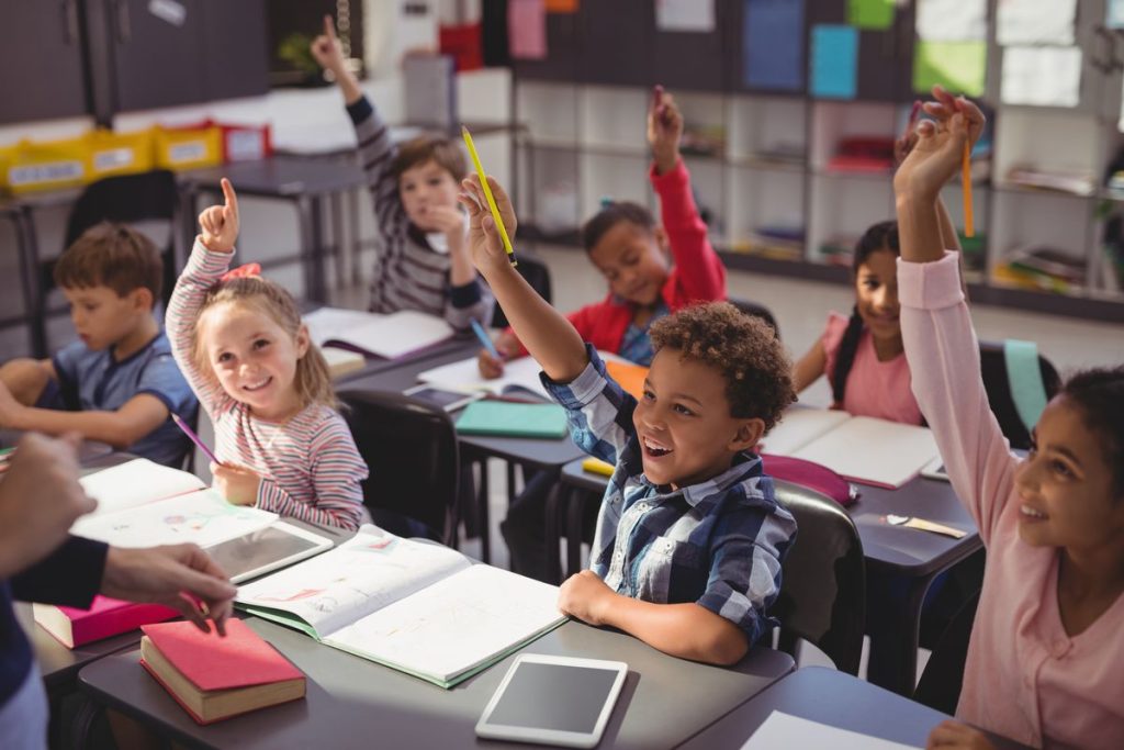Children raising their hand in class